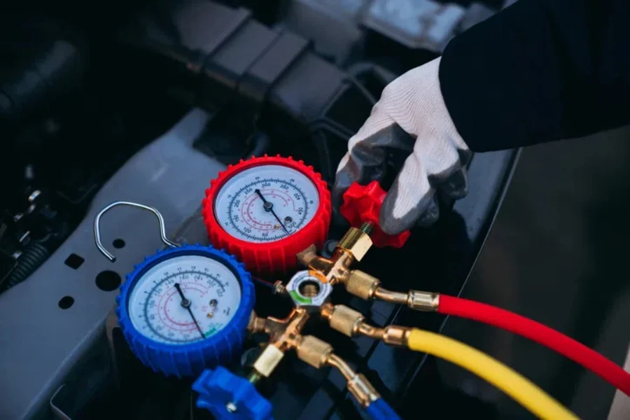 Close up hand of Mechanics inspect and check the refrigerant and fill the car air conditioner