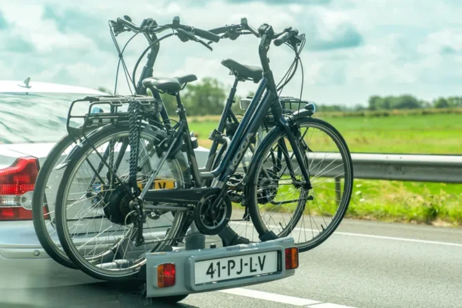 Vista de cerca del coche transporta bicicletas en un estante en la carretera