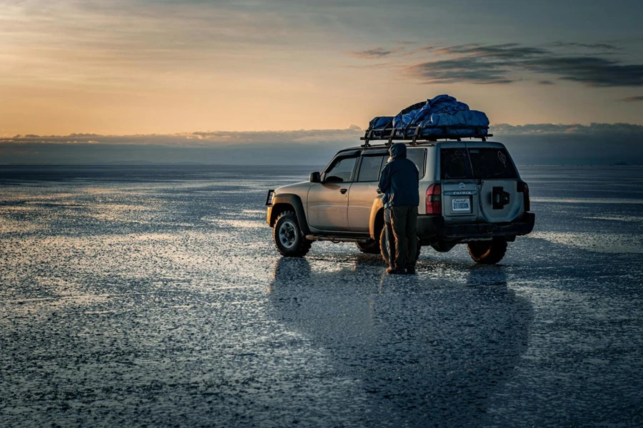 Paar steht neben einem Jeep in einer nassen, flachen Landschaft