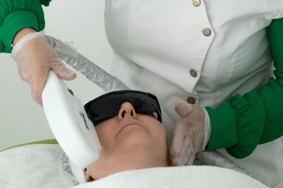 Médico fazendo procedimento facial com ferramenta laser