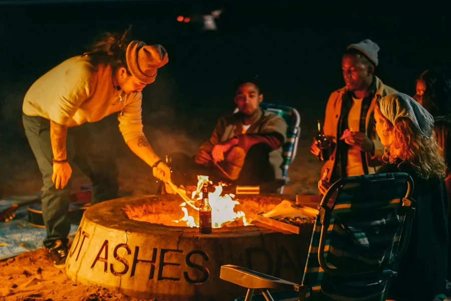 Gruppe von Freunden sitzt vor der Feuerstelle