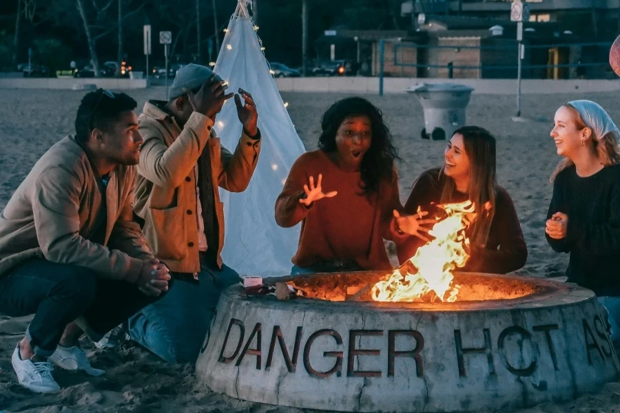 Grupo de amigos sentados em frente à fogueira