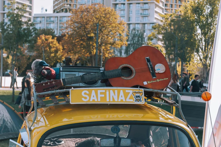 Gitarre und Kassettenspieler auf dem Dachgepäckträger eines alten gelben Käfers