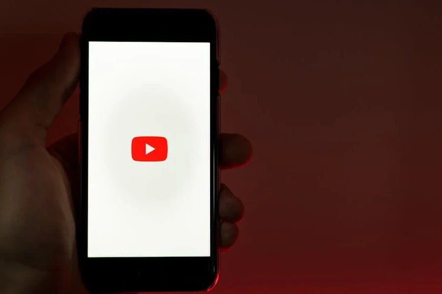 Tangan memegang telepon dengan YouTube terbuka