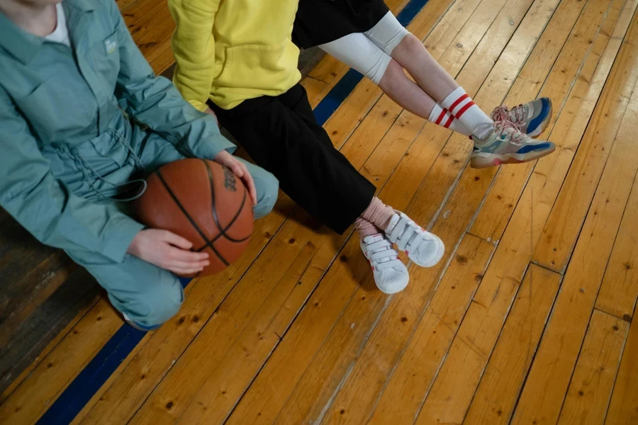 Bambini dentro una palestra con un pallone da basket