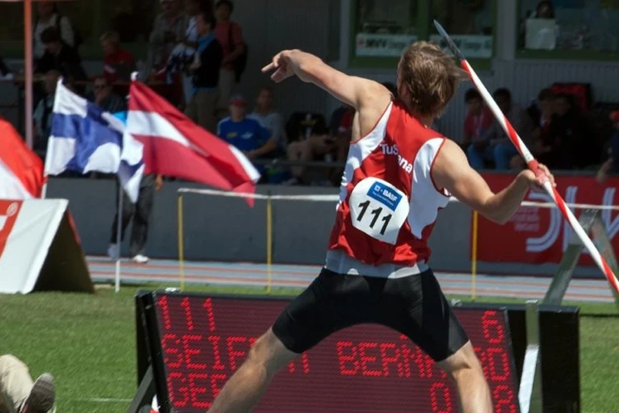 Mann in Sportkleidung beim Speerwurf