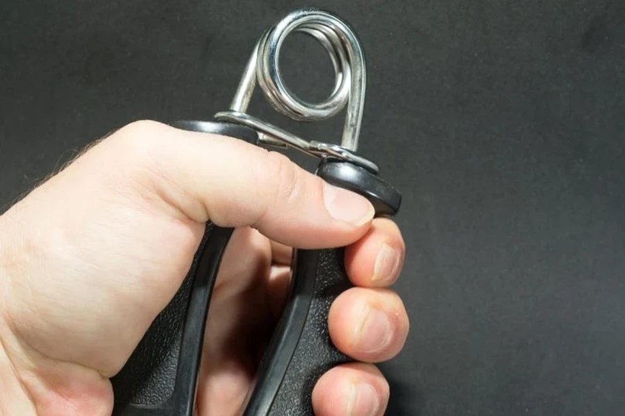 Man squeezing a grip trainer with high resistance