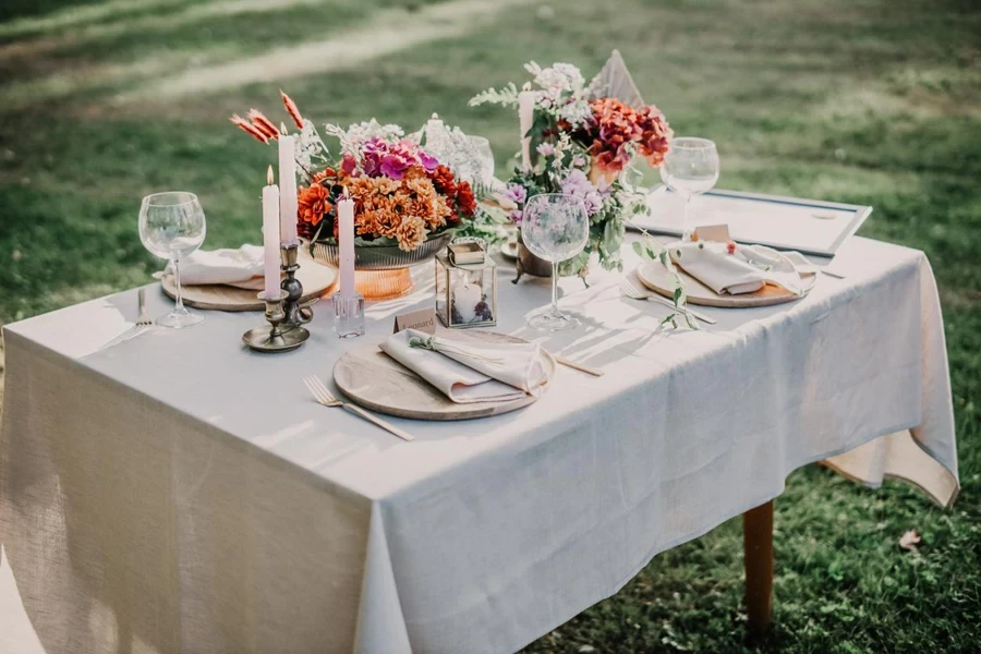 Moderner Hochzeitstisch mit Tellern, Besteck und Blumen dekoriert