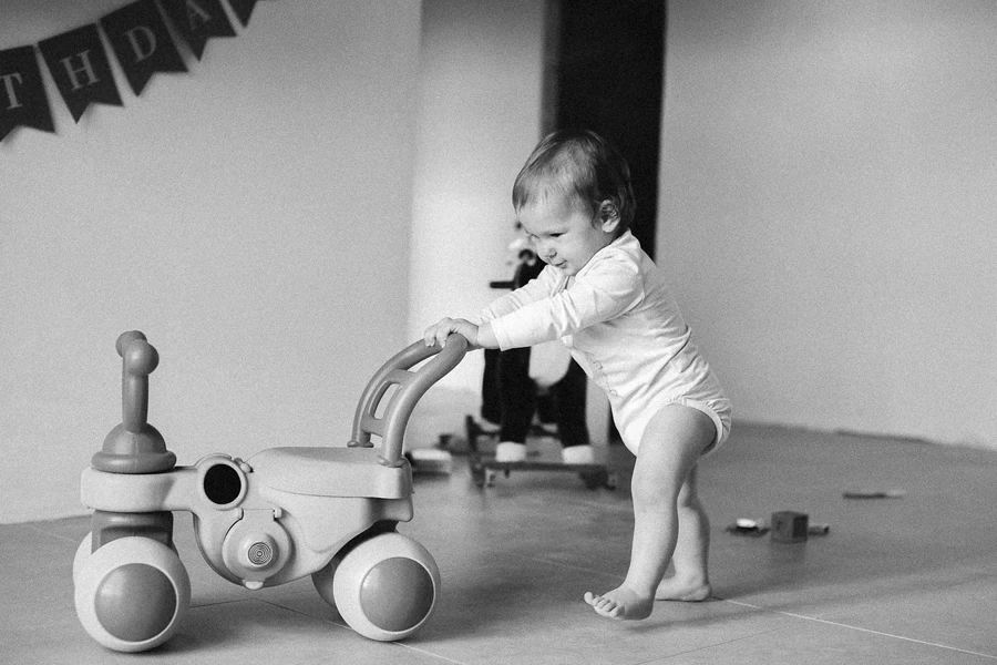 三輪車を押す幼児のモノクロ写真