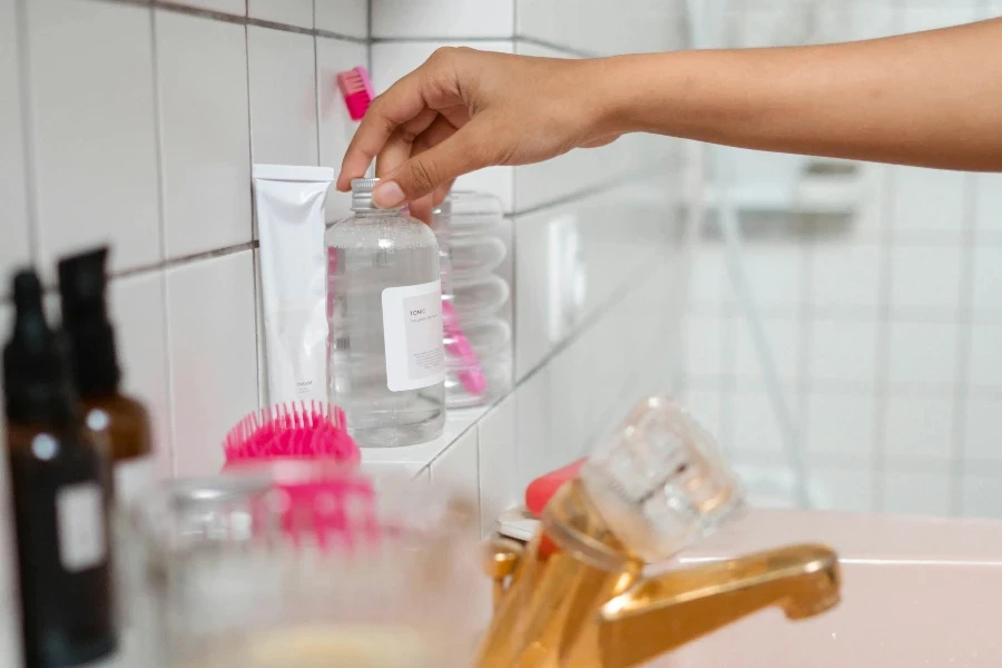 Persona Sosteniendo Una Botella De Vidrio Transparente