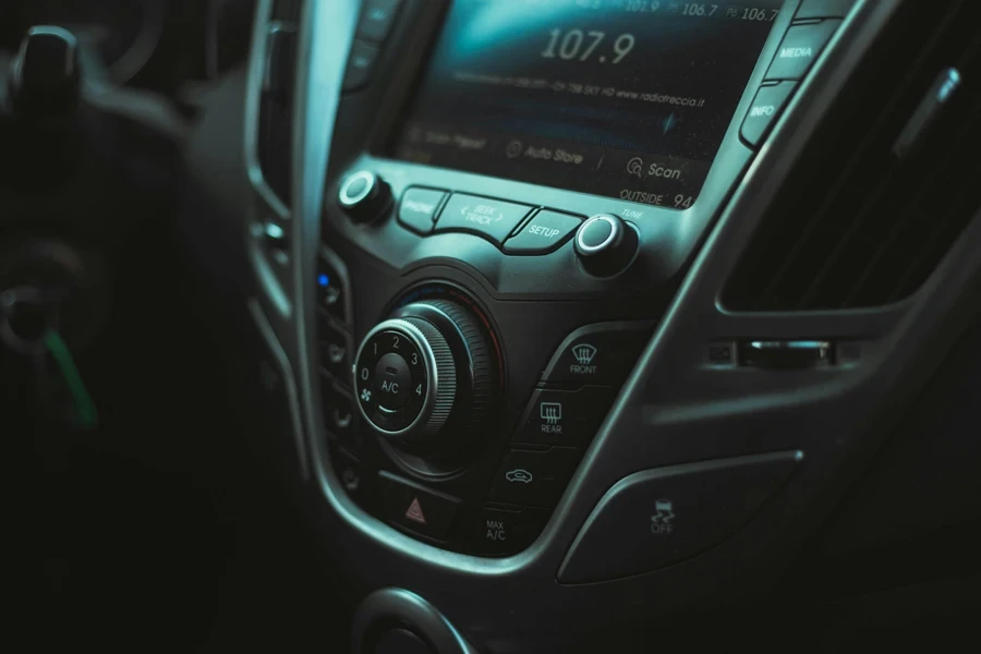 Foto do interior de um carro com rádio, botões e saída de ar