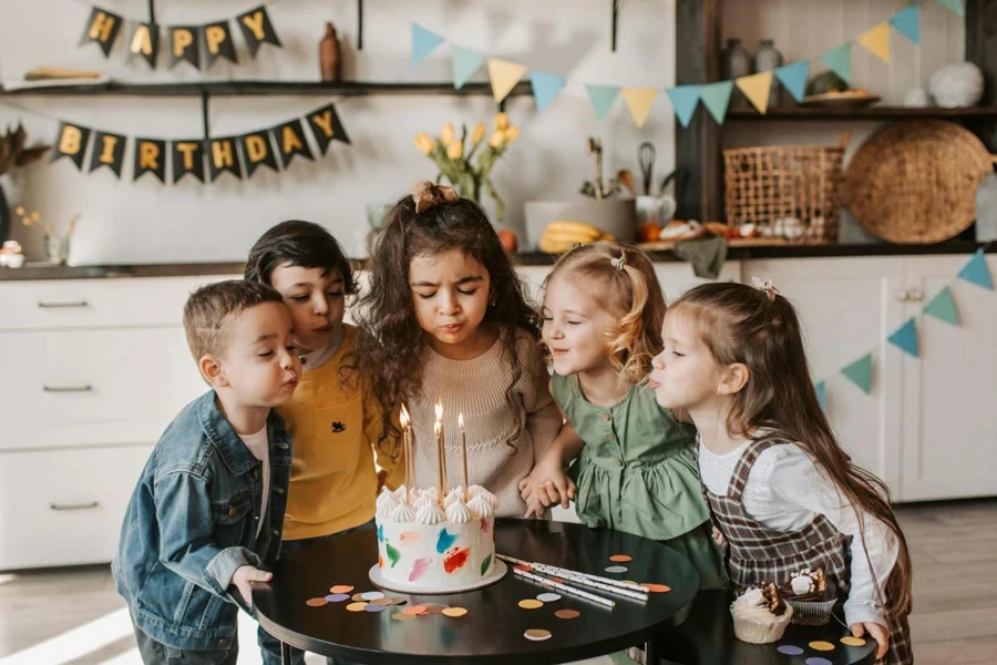 ケーキのろうそくを吹き消す子供たちの写真