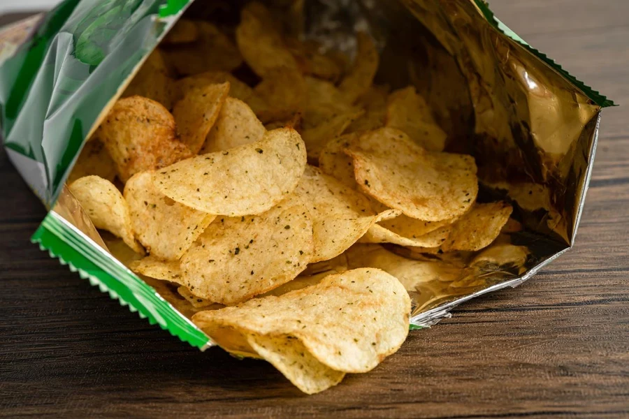 Chips de pommes de terre, délicieuses et épicées pour les chips, fines tranches frites, snack fast food dans un sac ouvert