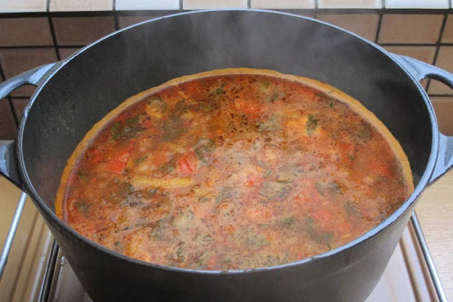 Bouillon épicé de volaille et de fruits de mer dans une casserole en cours de cuisson