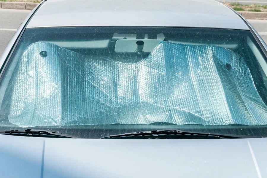 Sun reflector on the windscreen or windshield as protection of the car plastic indoor panel from direct sunlight and heat