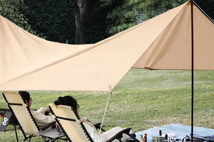 Two people relaxing under a sun shelter