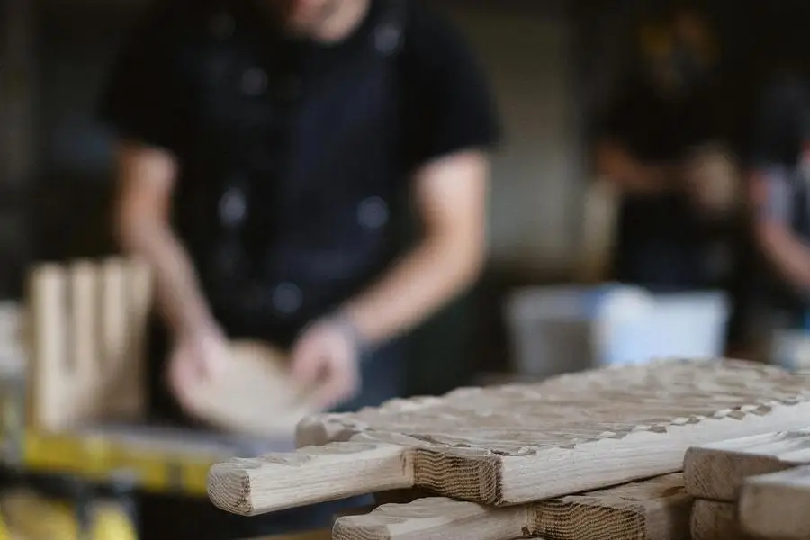 Unrecognizable craftsman working with wood at workbench by Anna Shvets