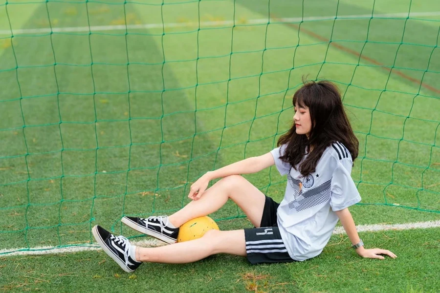 Femme assise près du but de football