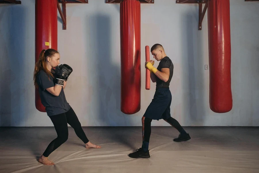 Une femme s'entraîne à la boxe avec un homme