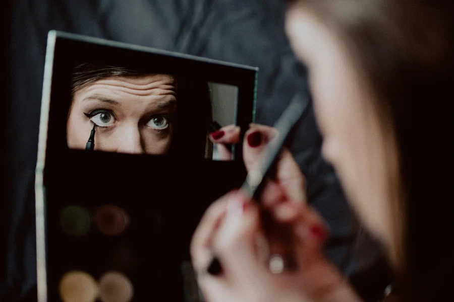 Mujer aplicando delineador de ojos negro líquido