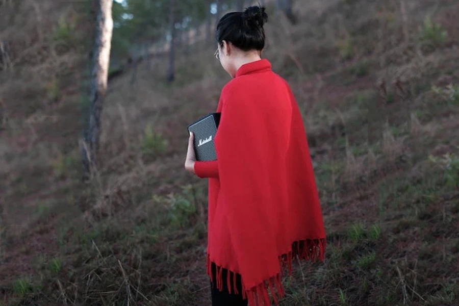 Donna che indossa un poncho rosso al ginocchio con nappe