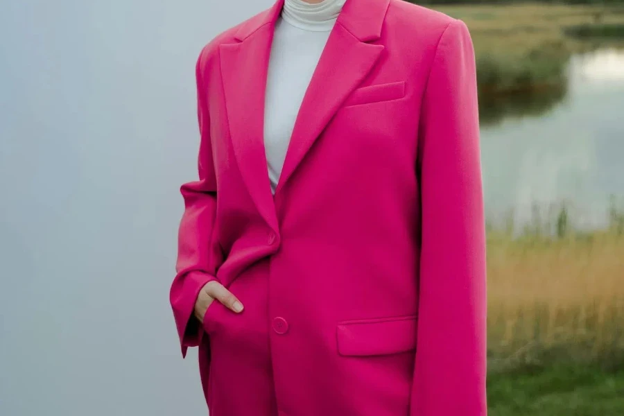 Seorang wanita berkelas dengan blazer double-breasted berwarna merah muda