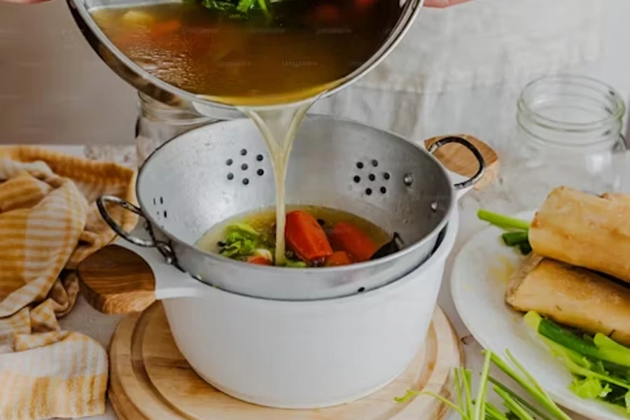 uma pessoa despejando uma panela de sopa em uma panela