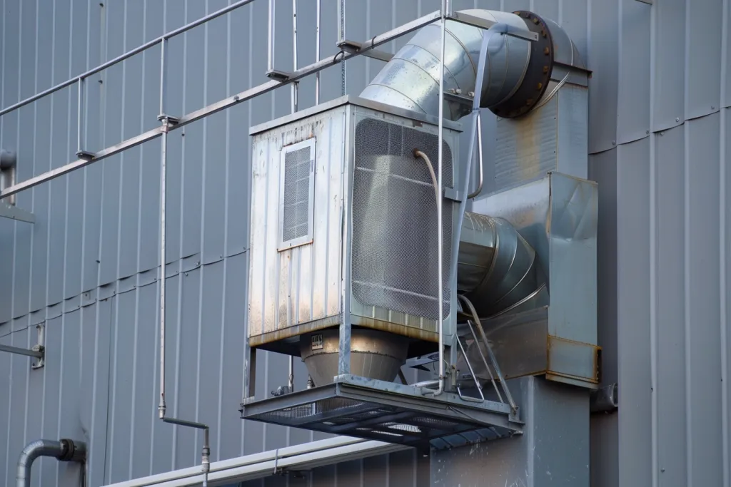 an industrial dust collection system mounted on the side of a building