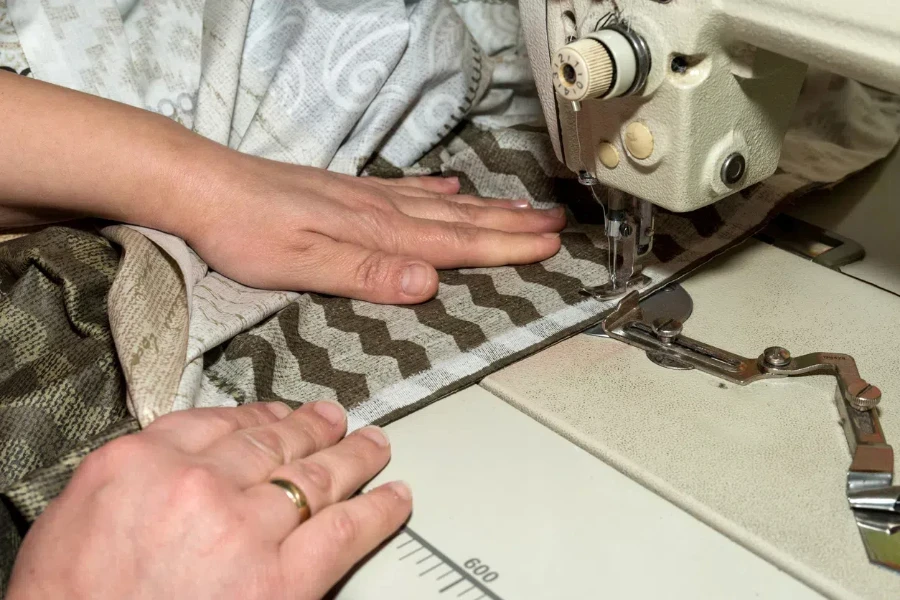 hands of seamstress working on sewing machine