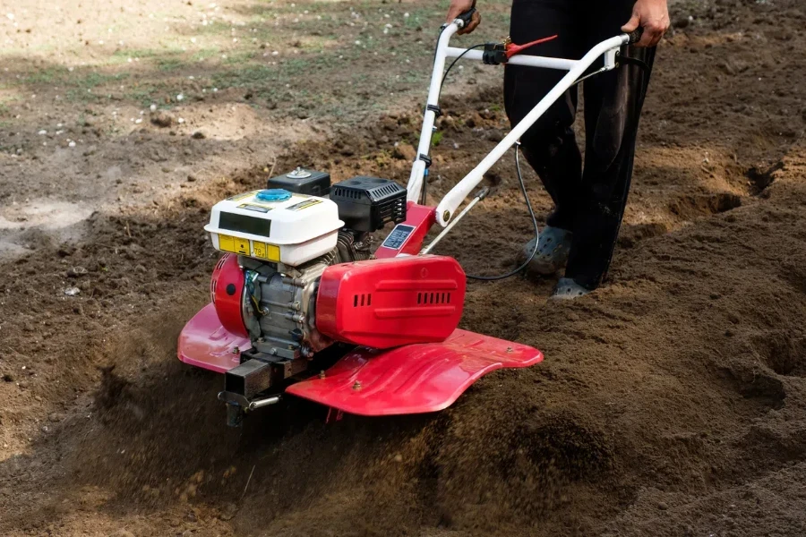 hombre trabajando en el jardín con máquina cultivadora de jardín