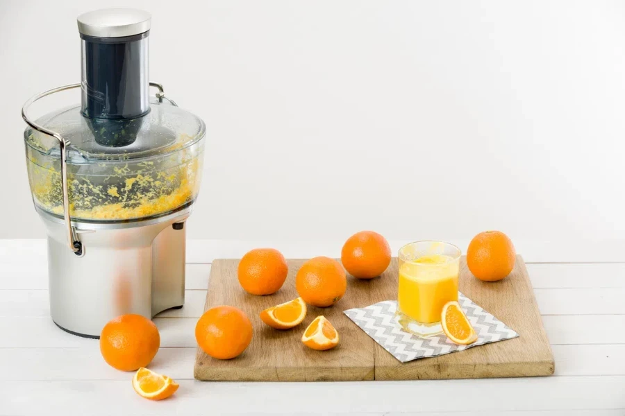 modern electric juicer and freshly prepared orange juice