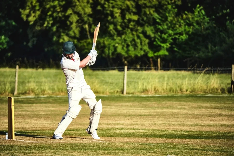 Männlicher Cricketspieler schlägt im Sonnenschein vor dem Wicket