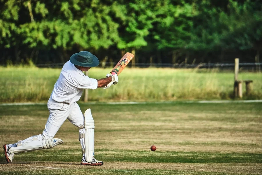 Mann schlägt Cricketball, während er eine Cricket-Sonnenbrille trägt