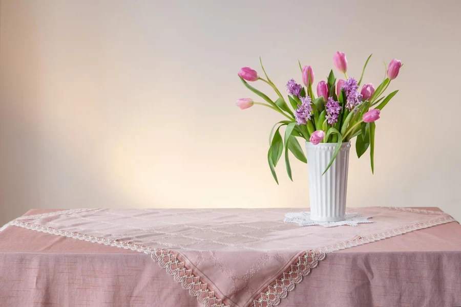 テーブルの上にビンテージ風の白い花瓶に入った春の花