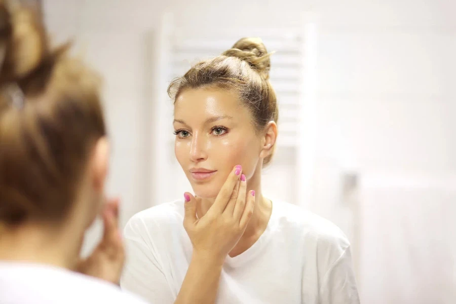 Woman in front of a mirror admiring glowing skin