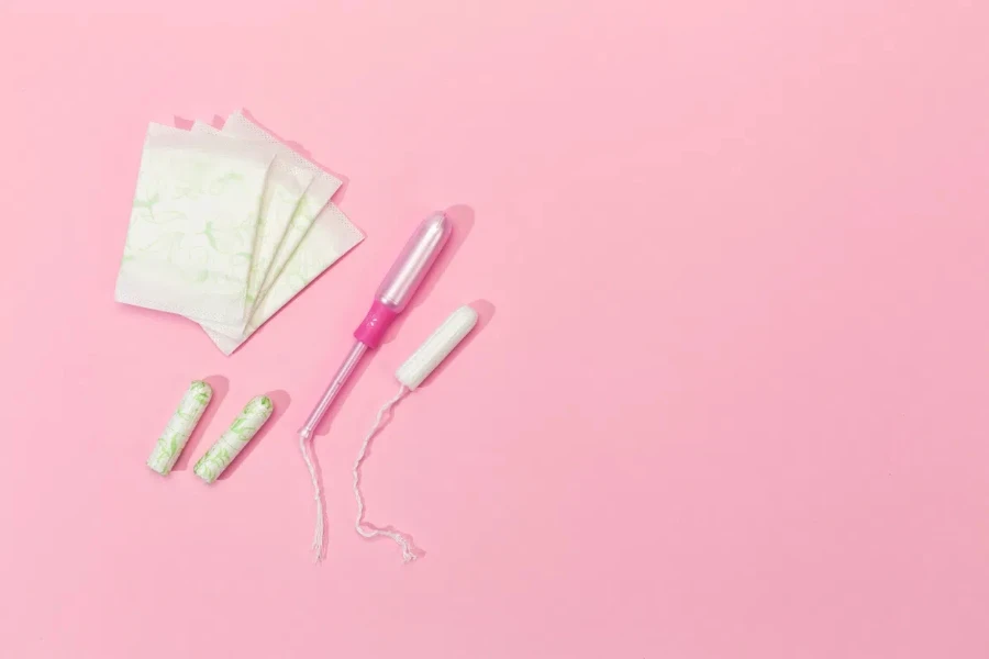 tampon wanita dan pembalut wanita dengan latar belakang merah muda