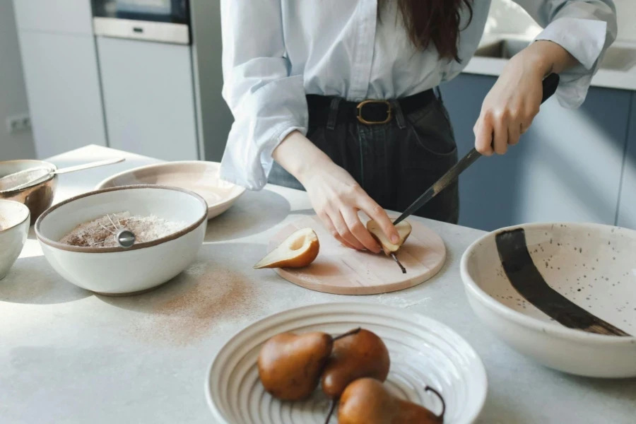 A Baker Cutting a Pear on a Kitchen Counter Top