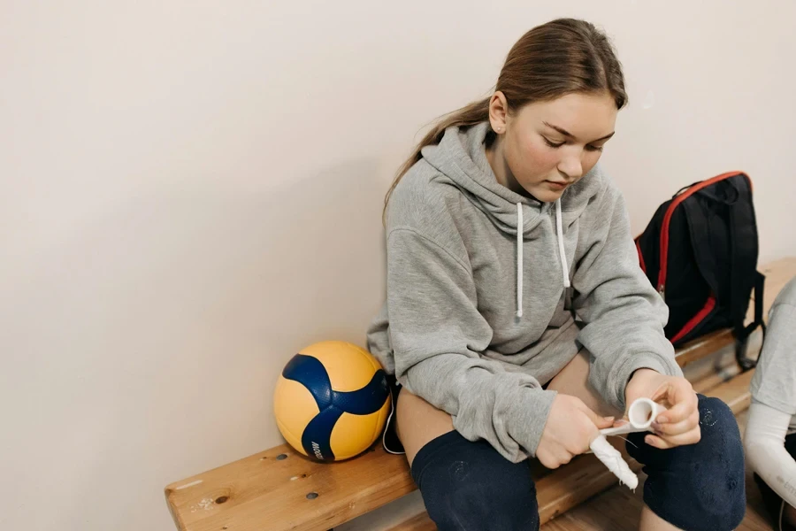 A Woman Putting Athletic Tape on Fingers