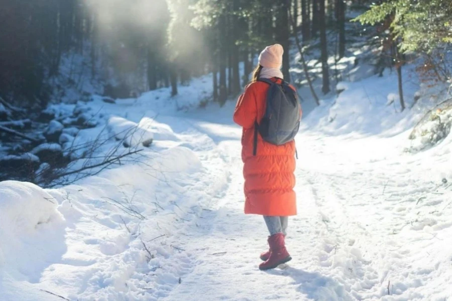 Ein Wanderer in roter Jacke und Winterwanderschuhen