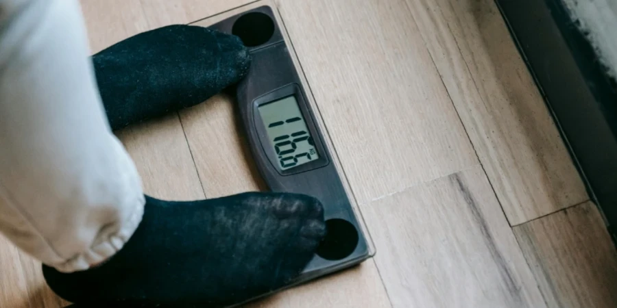 A person in socks standing on electronic weighing scale