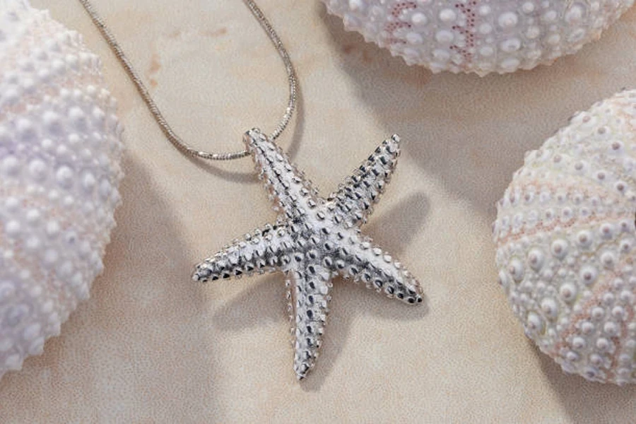 Collana con stelle marine in argento su sfondo ispirato alla spiaggia