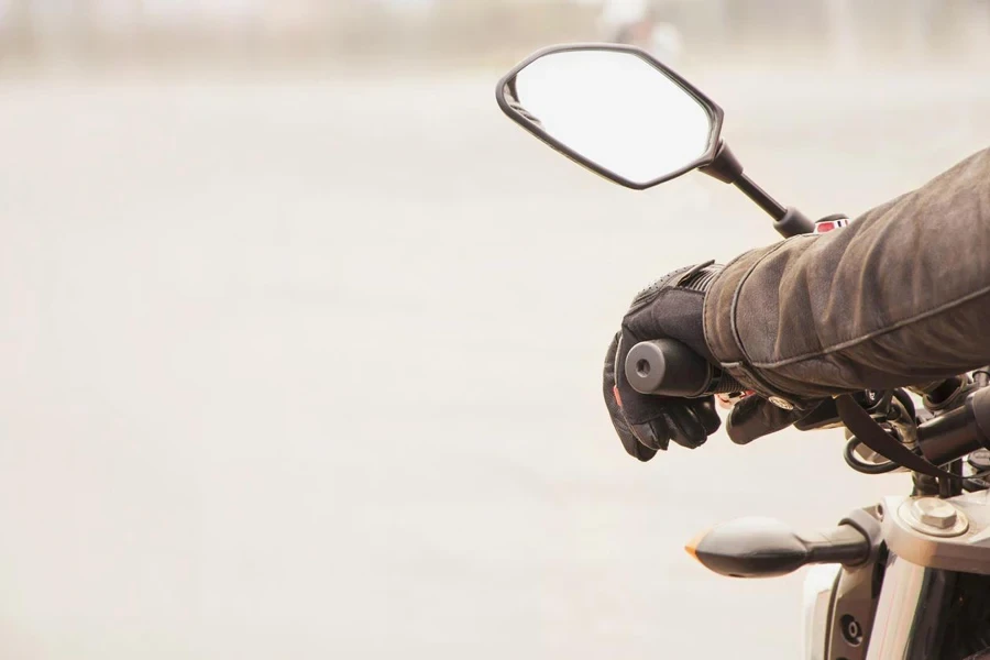 La mano del motociclista poggia sul volante della motocicletta