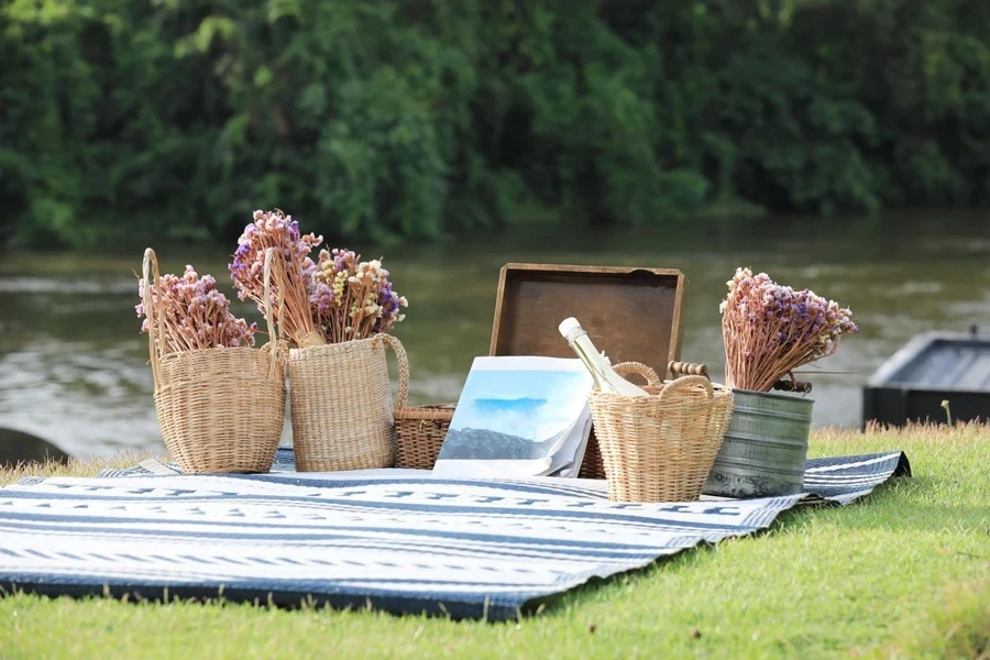 Book and flowers baskets on blue mat with river and forest in background