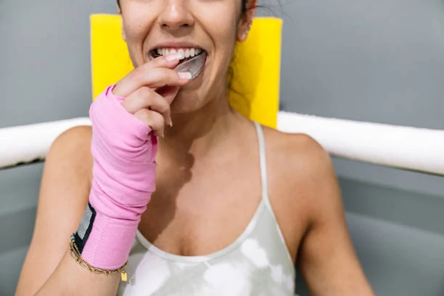 Female boxer placing clear stock mouthguard in mouth