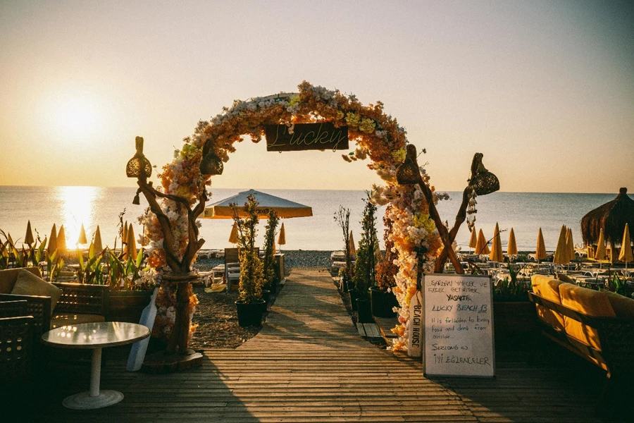 Blumenbogen bei einer Hochzeit am Strand bei Sonnenuntergang