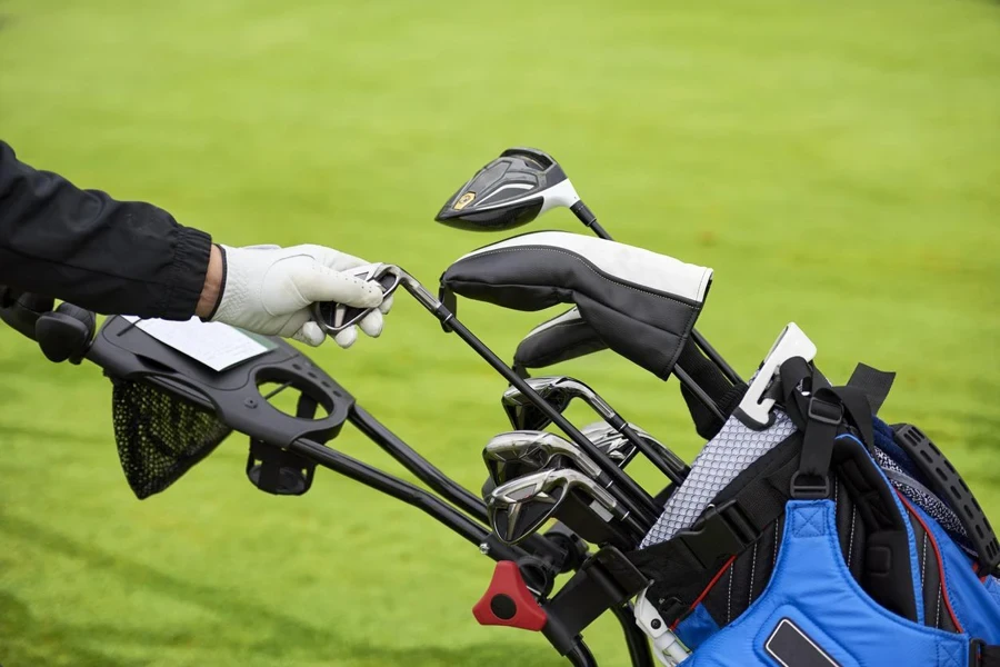 Golfer removes a golf club from the bag to shoot the ball from the fairway