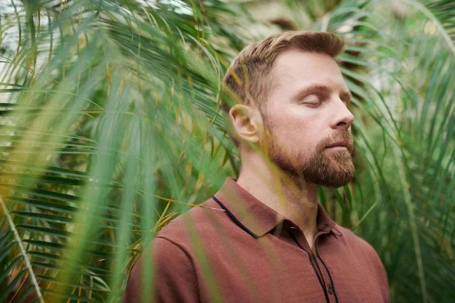 Un homme portant un polo rouge avec les yeux fermés