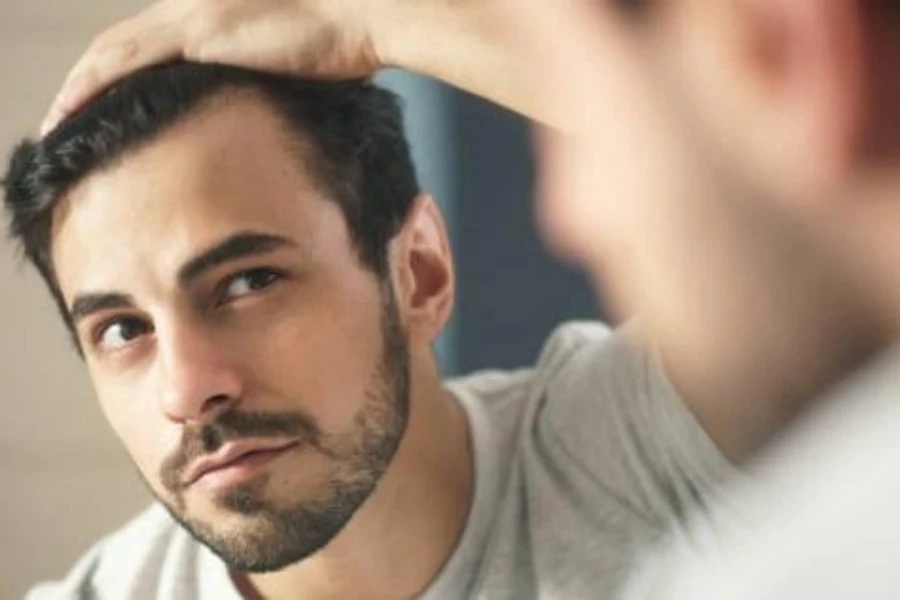 Man checking for signs of hair loss