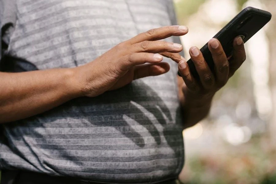 Mann scrollt auf seinem Telefon durch Anzeigen