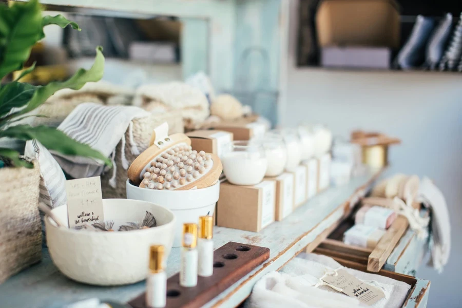 De nombreuses bougies parfumées placées près des brosses de massage et du parfum dans un magasin à vendre